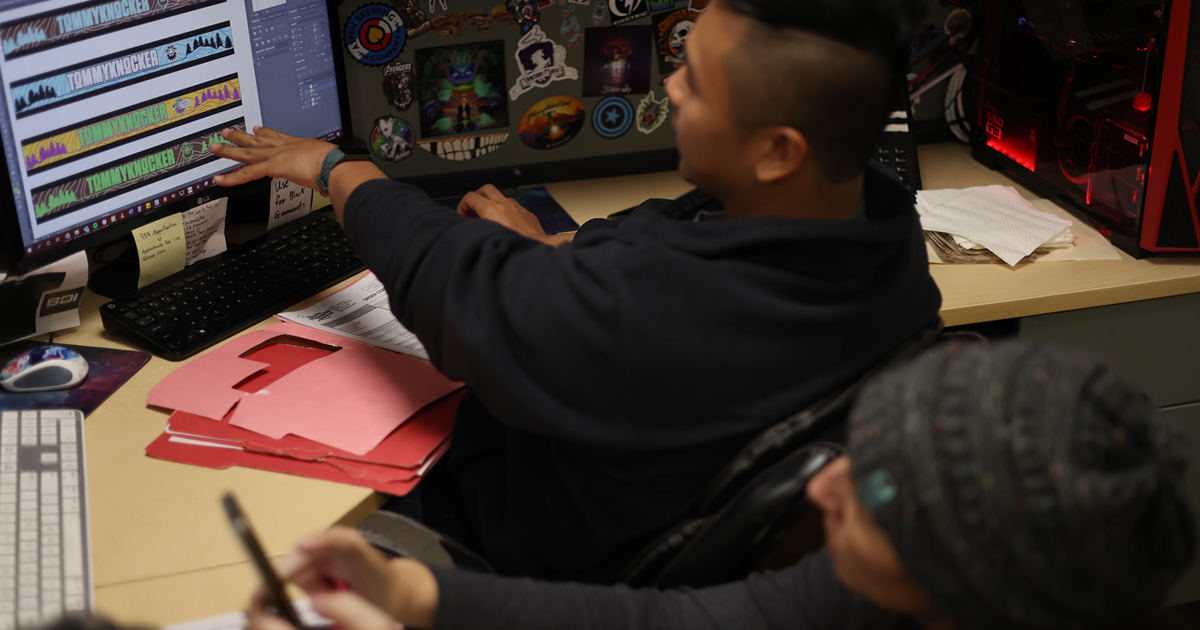 Rocky Mountain Apparel staff checking artwork on a computer